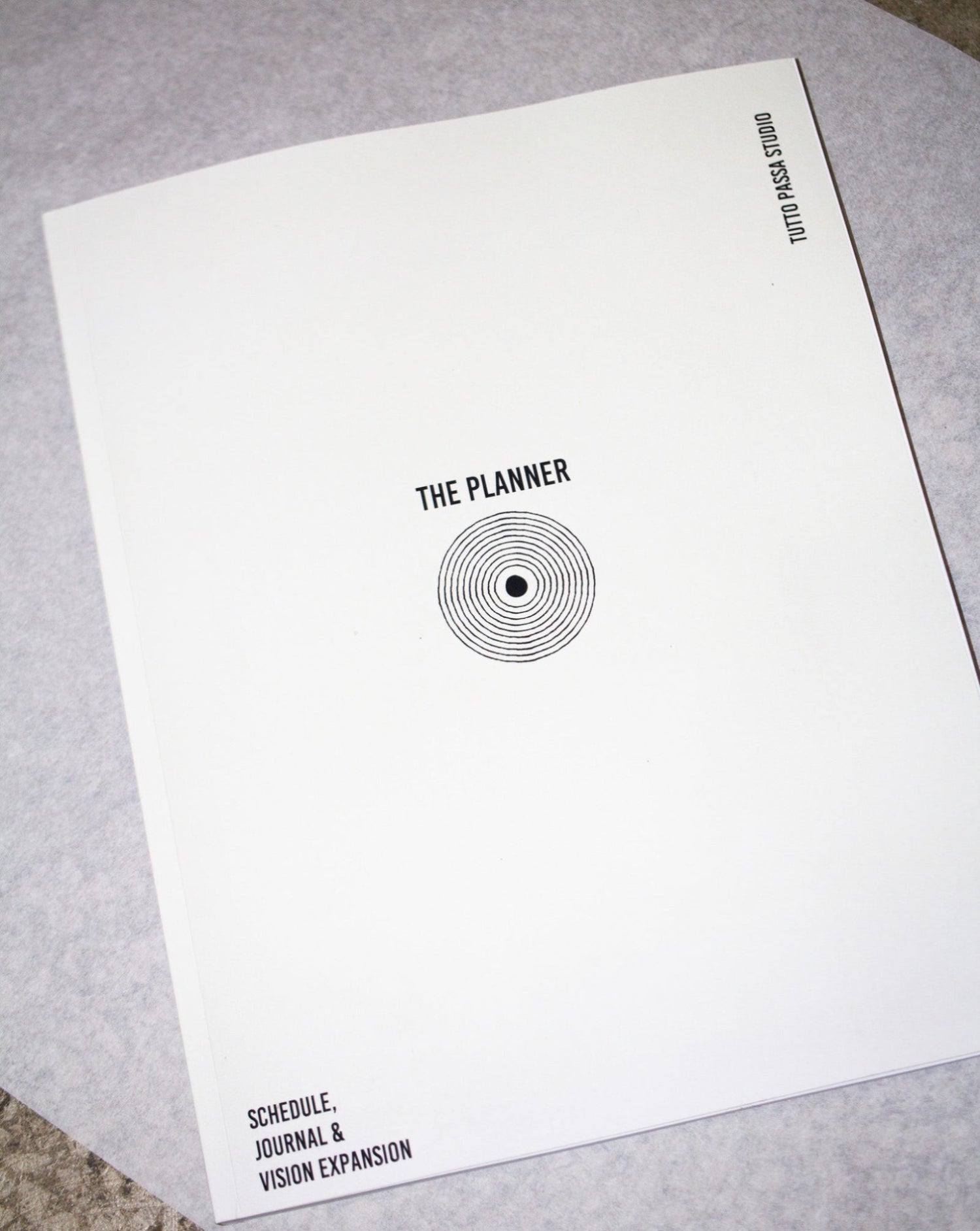 White planner with black text and design on a gray surface