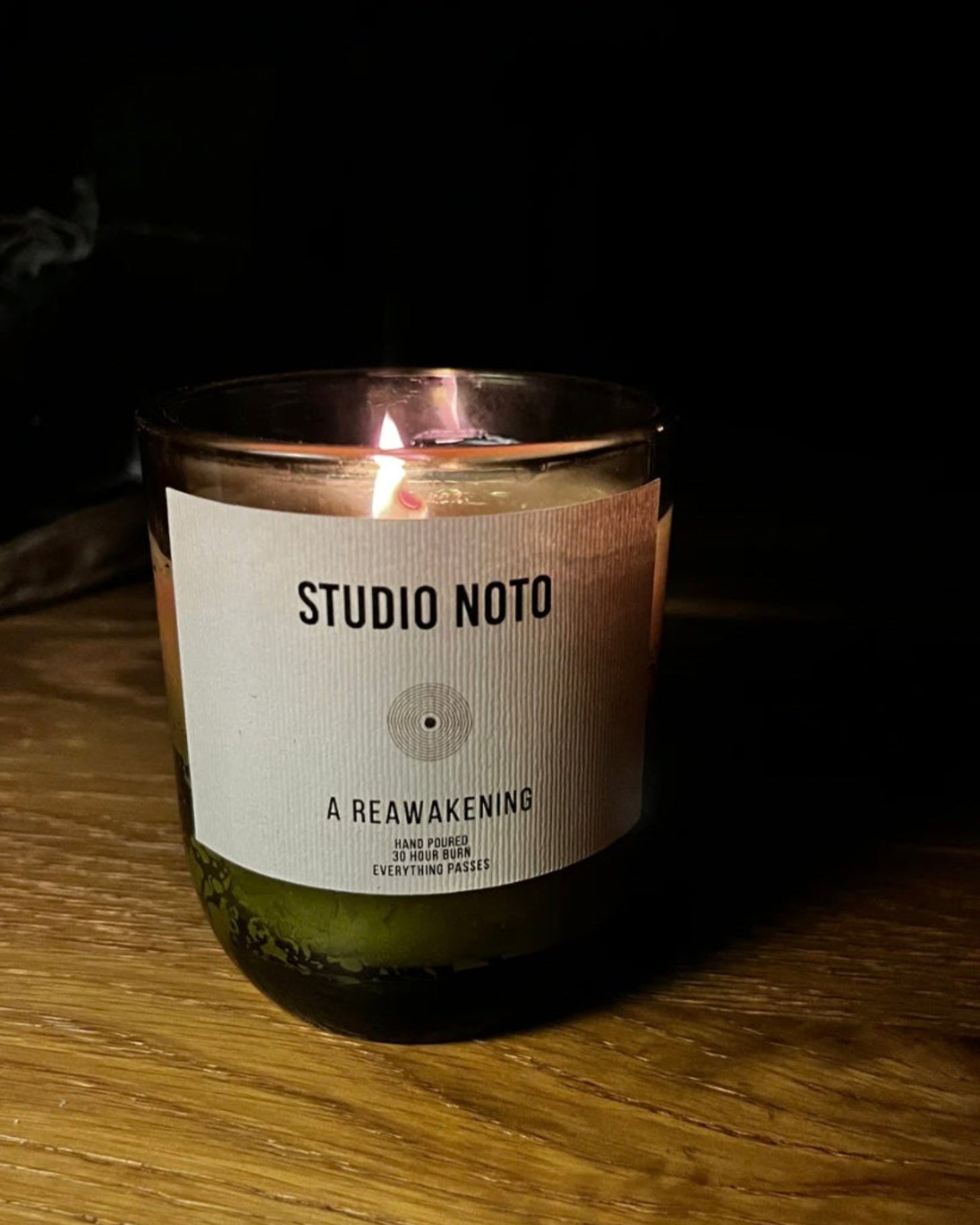 Candle with 'Studio Noto' label on a wooden surface